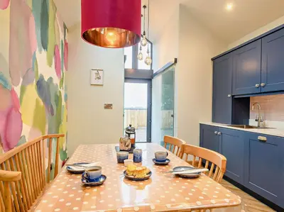 a dining room with a table and chairs and a kitchen at 1 Bed in Lockerbie 93110 in Lockerbie