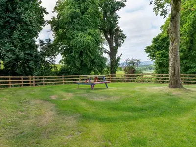 two children sitting on a park bench in a field at 1 Bed in Lockerbie 93110 in Lockerbie
