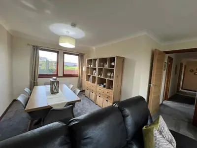 a living room with a couch and a table at 3 Bed in Mochrum 87541 in Mochrum