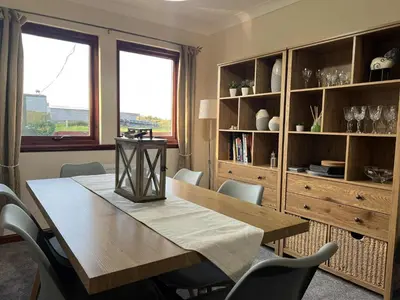 a dining room with a wooden table and chairs at 3 Bed in Mochrum 87541 in Mochrum