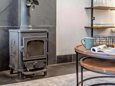 a stove in a kitchen with a table and a cup at 2 Bed in Ambleside oc-sz500 in Grasmere