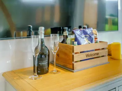 a bottle of wine and two glasses on a counter at 1 Bed in Keswick oc-82476 in Bassenthwaite