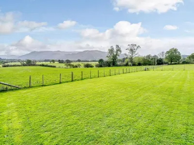 a field of green grass with a fence at 1 Bed in Keswick oc-82476 in Bassenthwaite
