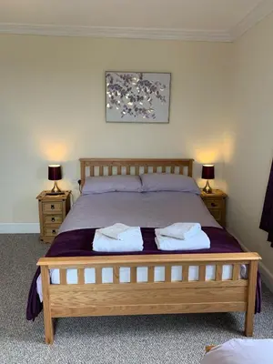 a bedroom with a bed with two towels on it at The Village Inn in Kirtlebridge