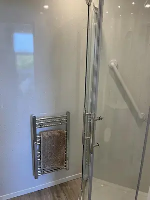 a shower with a glass door in a bathroom at The Village Inn in Kirtlebridge