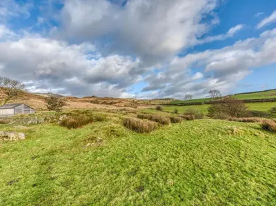 a field of grass with a house in the distance at 4 Bed in Broughton Mills 75286 in Seathwaite