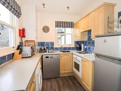a kitchen with wooden cabinets and stainless steel appliances at Walla Crag, Royal Oak House in Keswick