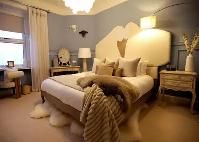 a bedroom with a large bed with a large headboard at Abbotsford Hotel in Ayr