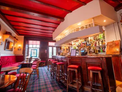a bar with red stools in a restaurant at Abbotsford Hotel in Ayr