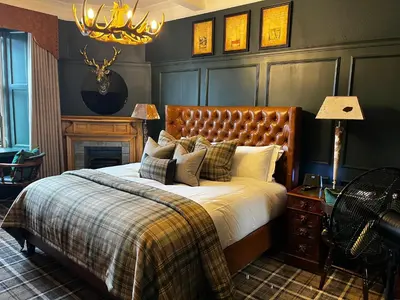 a bedroom with a bed and a chandelier at Abbotsford Hotel in Ayr