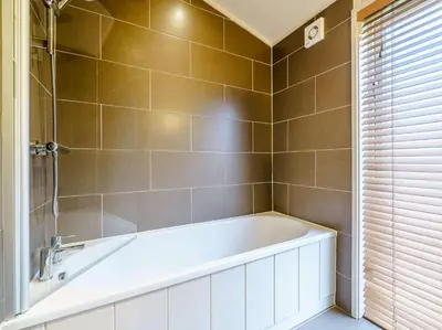 a bathroom with a white tub and a shower at 2 Bed in Caldbeck 80562 in Caldbeck