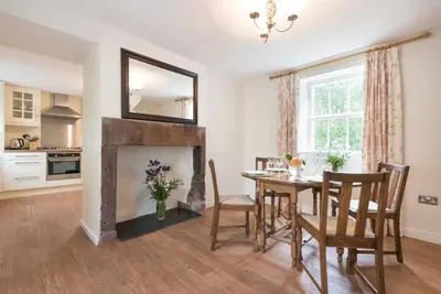 a dining room with a table and a fireplace at 2 Bed in Eskdale SZ346 in Santon Bridge