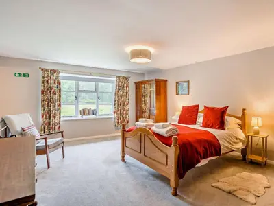 a bedroom with a large bed and a window at 4 Bed in Holmrook oc-sz158 in Eskdale