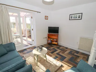 a living room with a couch and a table and a tv at Hillside Hideaway in Wigton