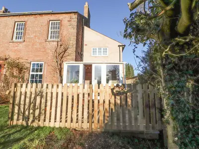 a wooden fence in front of a house at Hillside Hideaway in Wigton