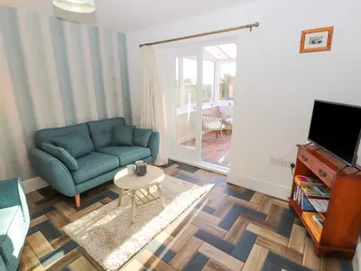 a living room with a blue couch and a table at Hillside Hideaway in Wigton