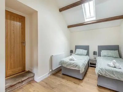 a bedroom with two beds and a door at Herdwick House - Uk42805 in Mungrisdale