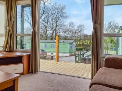 a room with a sliding glass door with a deck at Inglenook Lodge in Lamplugh