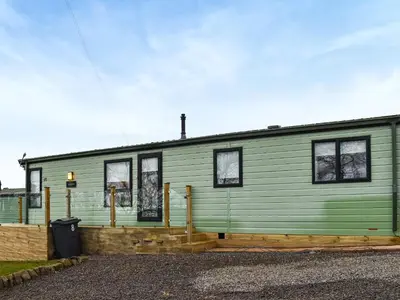 a green house with windows on the side of it at Inglenook Lodge in Lamplugh