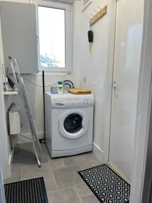 a washing machine in a bathroom with a window at Luxury 1BR Flat Central Dumfries Self Check-in, Parking, Wi-Fi in Dumfries