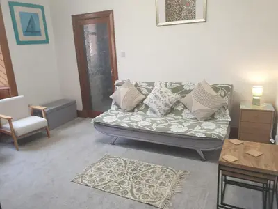a living room with a couch and a table at Luxury 1BR Flat Central Dumfries Self Check-in, Parking, Wi-Fi in Dumfries