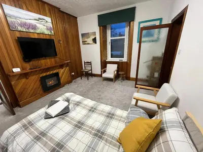 a hotel room with a bed and a tv at Luxury 1BR Flat Central Dumfries Self Check-in, Parking, Wi-Fi in Dumfries