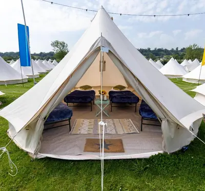 a large white tent with chairs in a field at Duke Travel Official TT Glamping - Douglas in Kirk Braddon