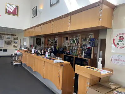 a bar in a store with a person standing at the counter at Duke Travel Official TT Glamping - Douglas in Kirk Braddon