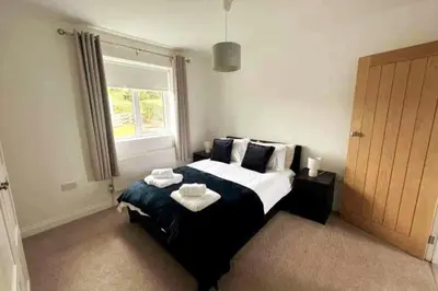 a bedroom with a large bed with towels on it at ERIN NEAMH - Magnificent sea views cosy cottage in Cumbria in Harrington