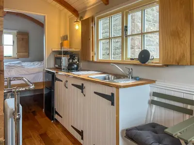 a kitchen with a sink and a counter top at Shepherds Hut at Maes Uldale stunning fell views and next door to popular cafe for sweet treats in Uldale
