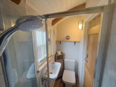 a small bathroom with a toilet and a sink at Shepherds Hut at Maes Uldale stunning fell views and next door to popular cafe for sweet treats in Uldale