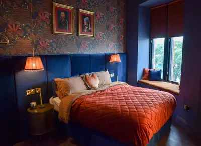 a bedroom with blue walls and a bed with a red blanket at The Bank - Rooms & Apartments by Coorie Doon Stays in Troon