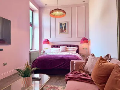 a bedroom with a purple bed and a couch at The Bank - Rooms & Apartments by Coorie Doon Stays in Troon