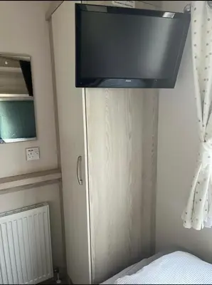 a flat screen tv hanging above a bed in a room at GDs Luxury Caravan Hire Turnberry Holiday Park in Turnberry