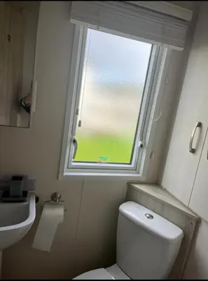 a small bathroom with a toilet and a window at GDs Luxury Caravan Hire Turnberry Holiday Park in Turnberry