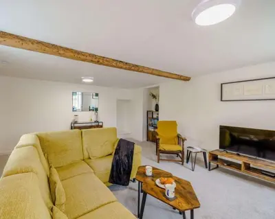 a living room with a yellow couch and a table at Barncroft: Dogs welcome, dog care services offered in Cockermouth