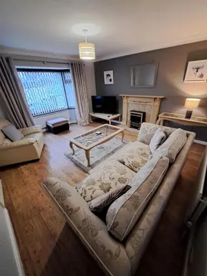 a living room with a couch and a fireplace at 17 The Park in Onchan