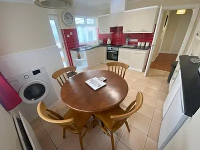 a kitchen with a wooden table and chairs in a kitchen at 17 The Park in Onchan