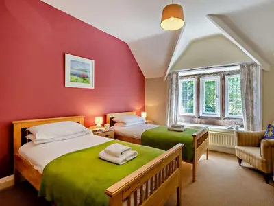 two beds in a room with red walls at 2 Bed in Holmrook oc-sz403 in Santon Bridge