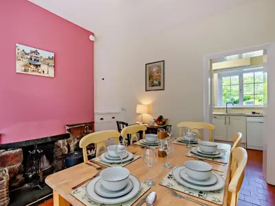 a dining room with a table and chairs and a red wall at 2 Bed in Holmrook oc-sz403 in Santon Bridge