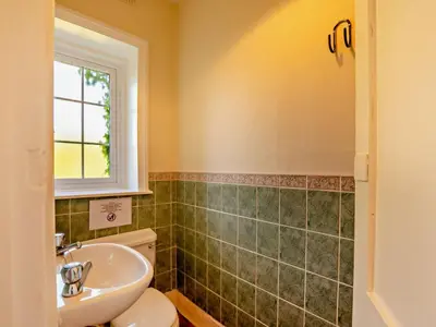a bathroom with a sink and a toilet and a window at 2 Bed in Holmrook oc-sz403 in Santon Bridge