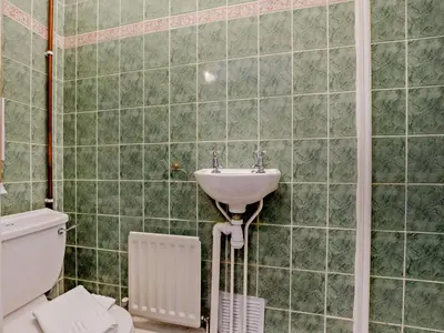 a green tiled bathroom with a sink and a toilet at 2 Bed in Holmrook oc-sz403 in Santon Bridge