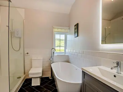 a bathroom with a tub and a toilet and a sink at 2 Bed in Holmrook oc-sz403 in Santon Bridge