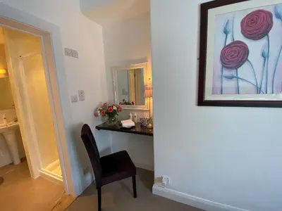 a room with a desk with a chair and a mirror at Number 10 Bed & Breakfast in Keswick
