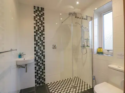 a bathroom with a shower and a toilet and a sink at Merse End in Dalbeattie