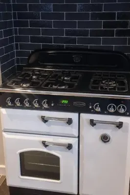 a stove in a kitchen with a black wall at Luxury Lake District Retreat above Ennerdale in Kirkland