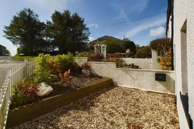 a garden outside a house with a white fence at Luxury Lake District Retreat above Ennerdale in Kirkland