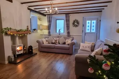 a living room with a couch and a christmas tree at Luxury Lake District Retreat above Ennerdale in Kirkland