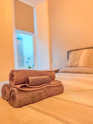 a pile of towels sitting on top of a bed at Barassie, Troon in Troon