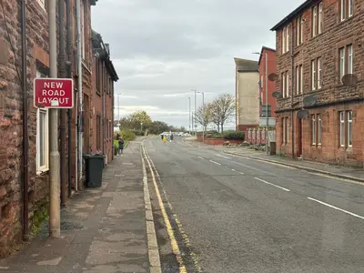 an empty street with a new road limit sign on a building at Barassie, Troon in Troon